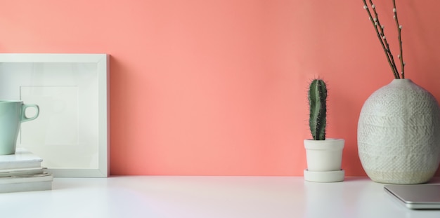 Cadre blanc sur l'espace de travail de bureau blanc