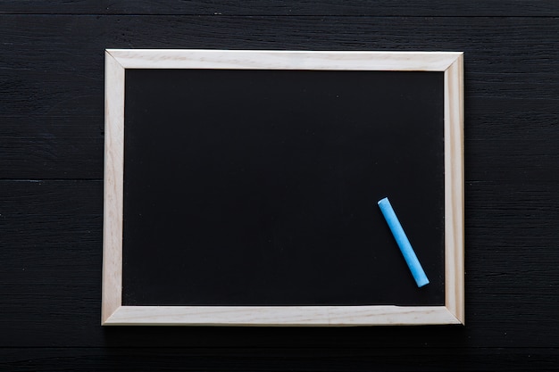 Photo cadre en bois blanc avec de la craie à l'intérieur sur tableau noir