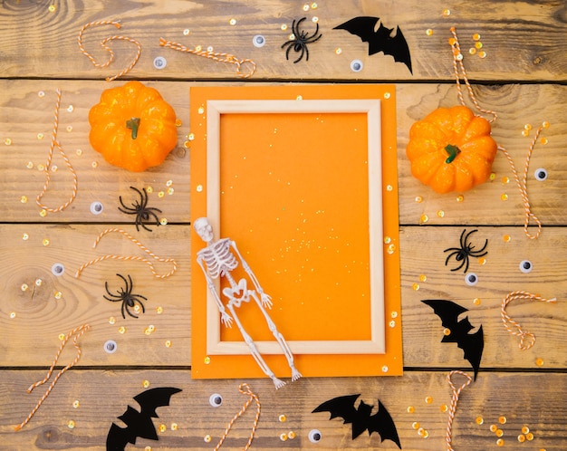 Photo cadre en bois avec squelette de citrouille araignées et chauves-souris sur un fond en bois un thème festif d'halloween espace vide pour le texte