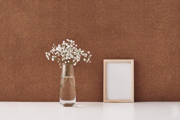 Cadre en bois et vase à fleurs blanches