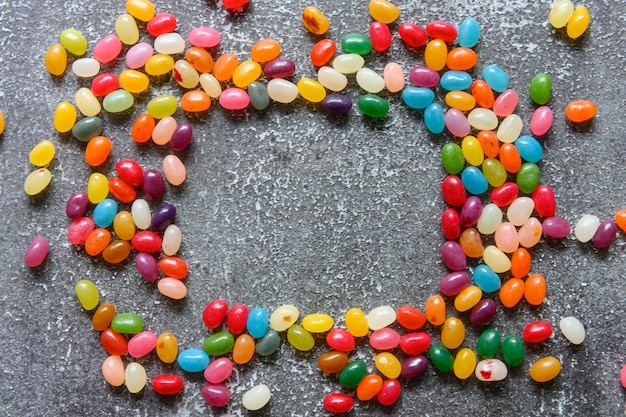 Photo cadre de bonbons colorés sur fond gris rustique avec espace de copie