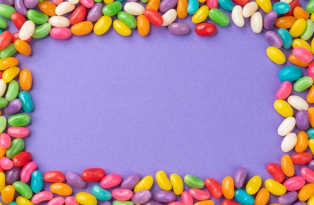 Cadre de bonbons colorés sur fond violet avec espace de copie