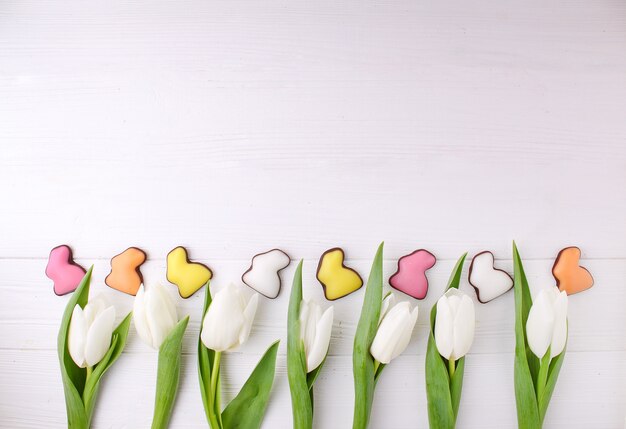 Cadre De Bonbons Pour Célébrer Pâques. Tulipes Blanches Et Lapin Colorés Au Chocolat.