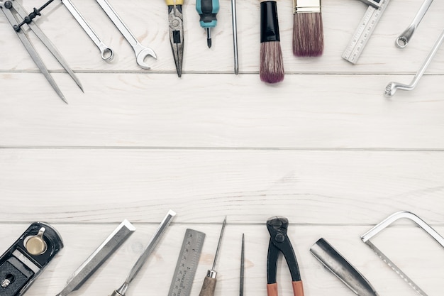 Cadre de bordure d'outils de travail sur une table en bois blanc avec espace de copie. Vue de dessus