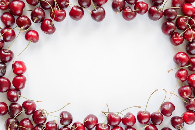 Cadre de cerises rouges sur fond blanc