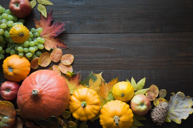 Cadre de citrouille et d'érable feuilles sur une planche en bois avec motif automne vue de dessus