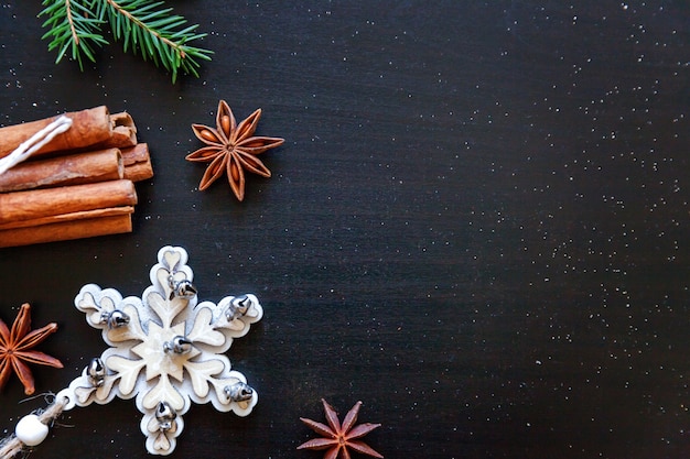 Cadre de composition de Noël nouvel an fait d'objets d'hiver sapin ornement de branche de cannelle sur fond noir foncé