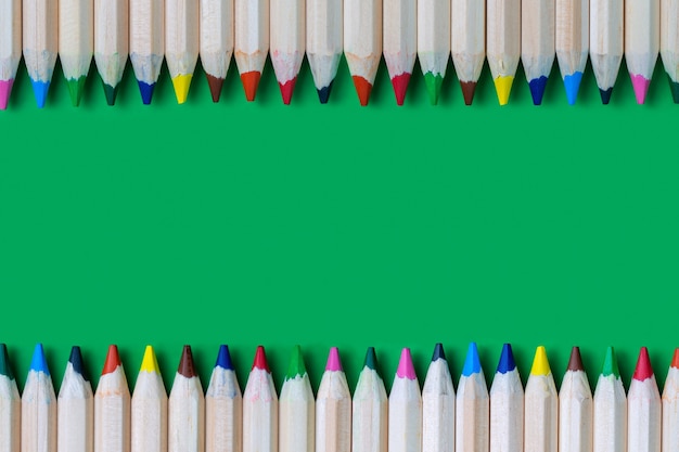 Cadre de crayons de couleur sur une surface verte