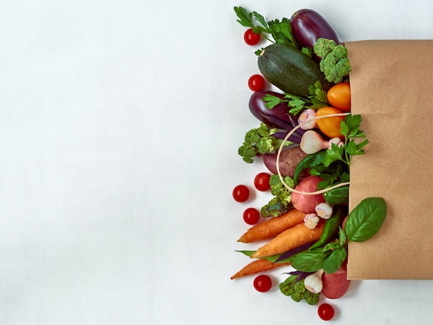 Cadre de divers légumes isolés sur un mur blanc, vue de dessus. Cadre d'aliments biologiques avec un espace pour le texte.