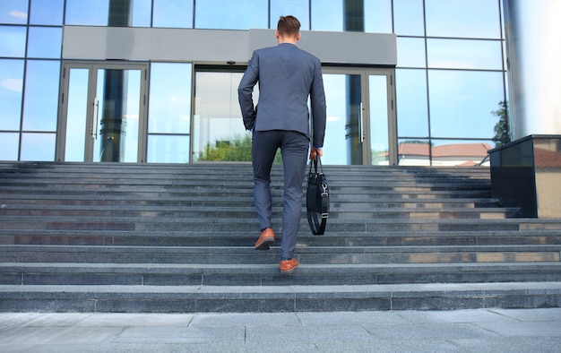 Cadre d'entreprise avec une mallette qui monte les escaliers.