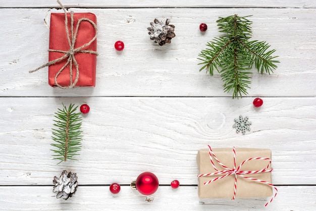 cadre fait de cadeau de Noël, pommes de pin, branches de sapin, boule rouge et baies