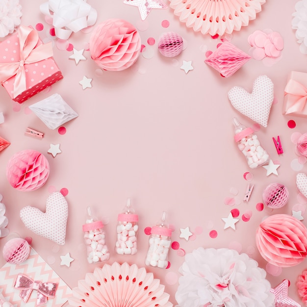 Cadre fait de décorations en papier rose et blanc, bonbons, coeurs, cadeaux, confettis pour la fête de bébé. Mise à plat, vue de dessus