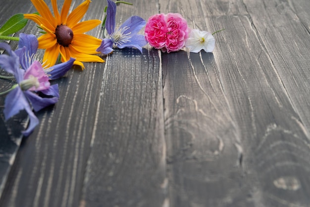 Cadre de fleurs de fleurs sauvages sur un fond de bois noir