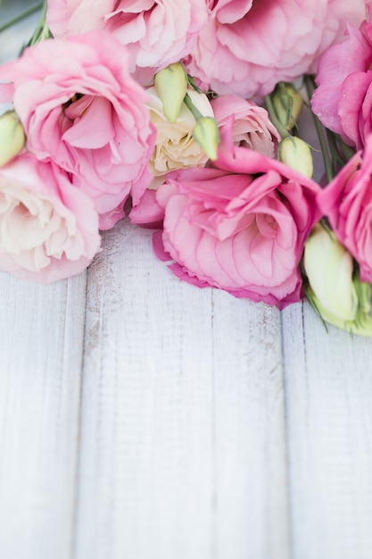 Photo cadre de fleurs roses fraîches sur table en bois