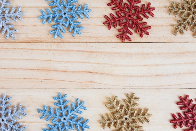 Cadre de flocons de neige colorés sur fond en bois ancien