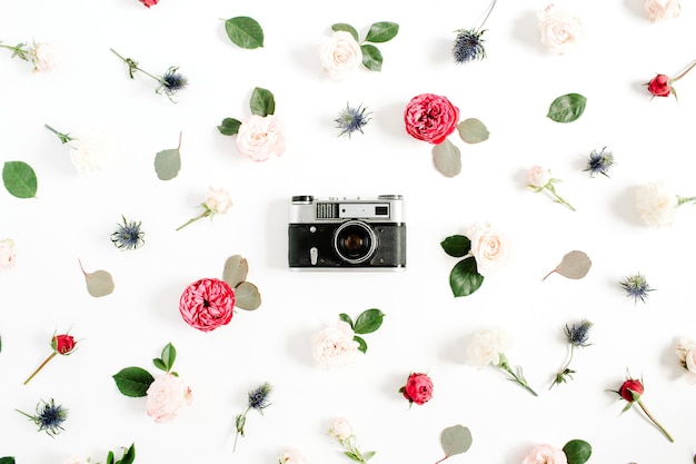 Cadre floral plat laïque avec appareil photo rétro vintage, motif de boutons de fleurs rose rouge et beige sur blanc