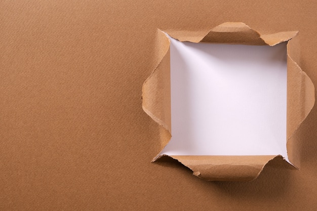 Cadre de fond blanc avec un trou carré de papier brun déchiré