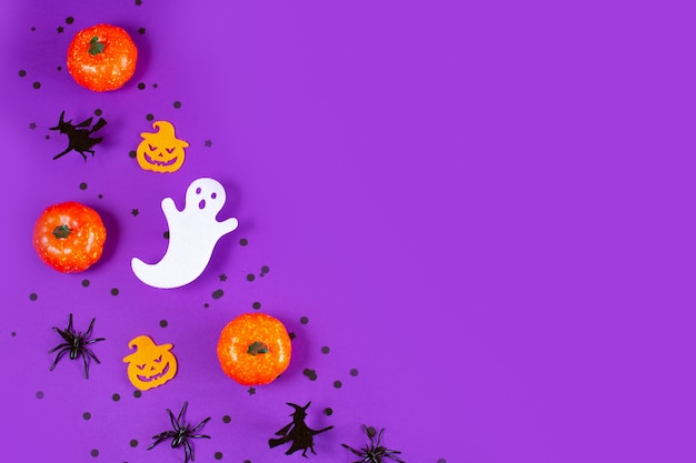 Cadre d'Halloween avec fantôme de citrouilles et araignées sur fond violet