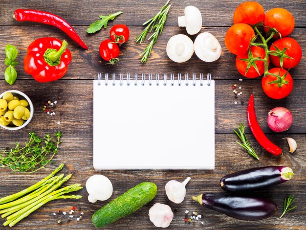 Cadré avec des légumes et des herbes sur fond de table en bois