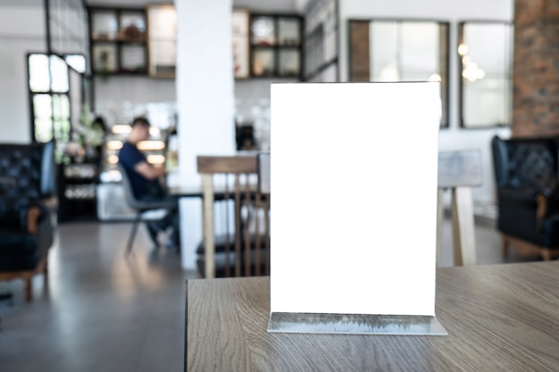 Cadre de menu maquette écran blanc se tenant sur la table en bois en arrière-plan