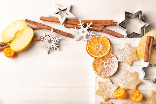 Cadre de Noël avec des biscuits crus et de la cannelle sur fond de bois