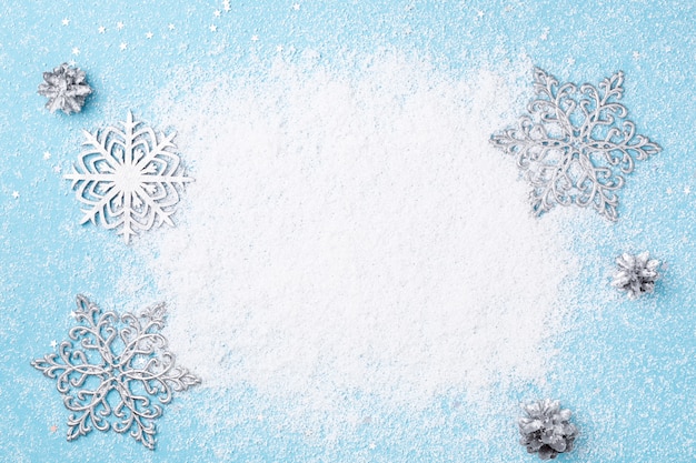 Photo cadre de noël bleu clair de neige et flocons de neige argentés.