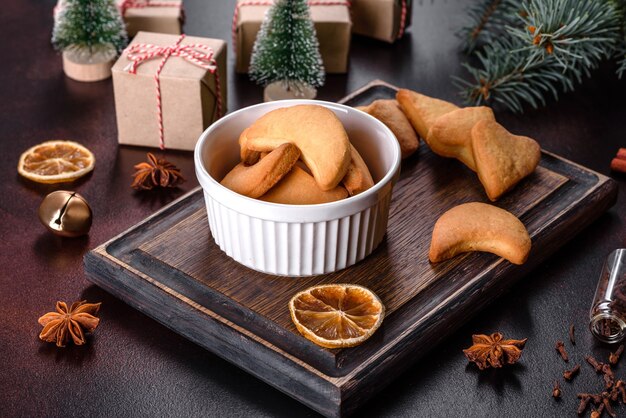 Cadre de Noël avec des branches de sapin, des biscuits de pain d'épice, des épices et des anneaux d'orange séchés