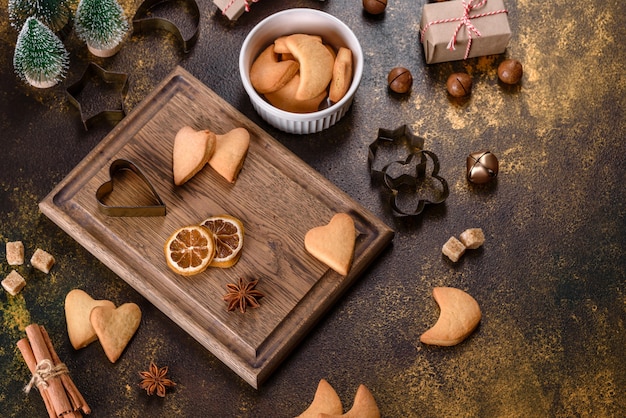 Cadre de Noël avec des branches de sapin, des biscuits de pain d'épice, des épices et des anneaux d'orange séchés