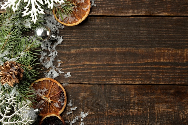 Cadre de Noël avec des branches de sapin et des décorations sur fond de bois brun