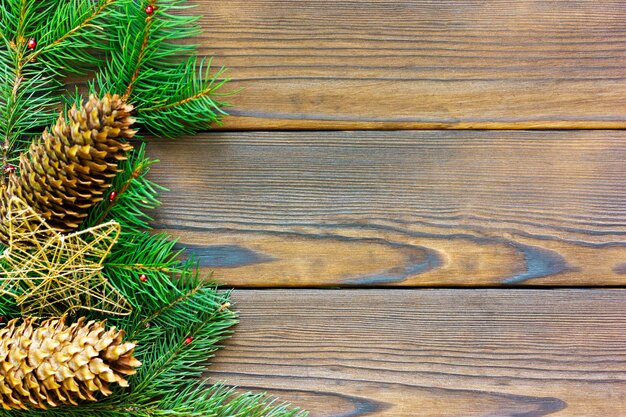 Cadre de Noël avec des cônes de branches de sapin sur une vue de dessus de table en bois foncé avec un espace pour le texte