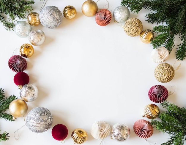 Cadre de Noël créatif plat avec des branches de sapin et différentes boules de Noël.