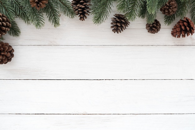 Cadre de Noël fait de feuilles de sapin, pommes de pin et coffret cadeau avec décoration rustique éléments sur bois blanc