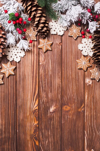 Photo cadre de pains d'épice et décor d'hiver sur un fond en bois.