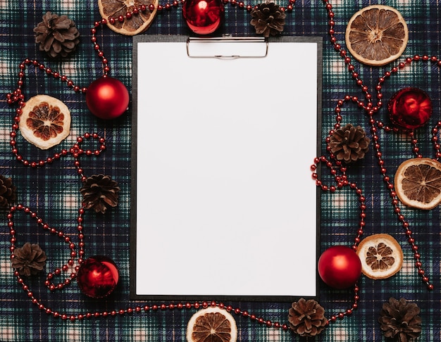 Photo cadre en papier de noël nouvel an, style flatley avec une vue de dessus avec des décorations de noël faites de boules, cônes, cannes de noël sur fond dans une cage. place pour votre texte