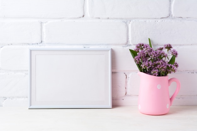 Cadre paysage blanc avec des fleurs violettes en pichet rose à pois