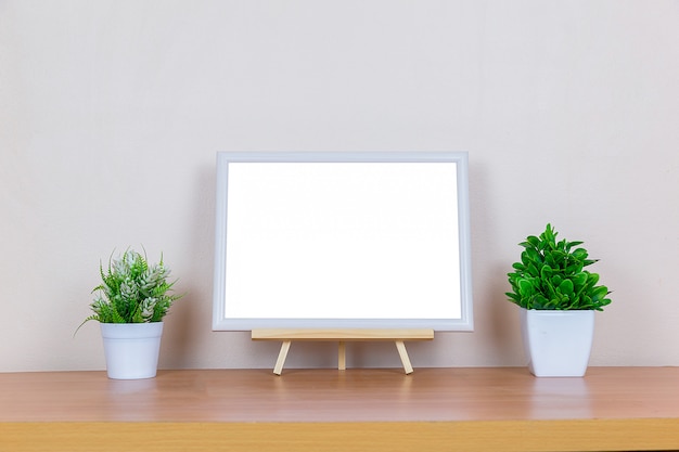 cadre photo blanc sur table en bois.