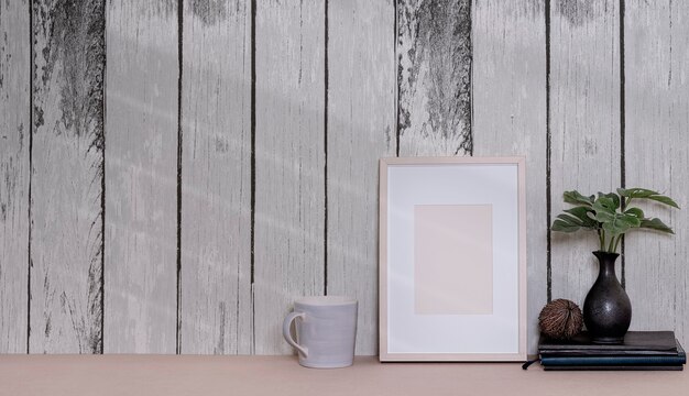 Cadre photo en bois blanc sur la table avec vieux mur en bois