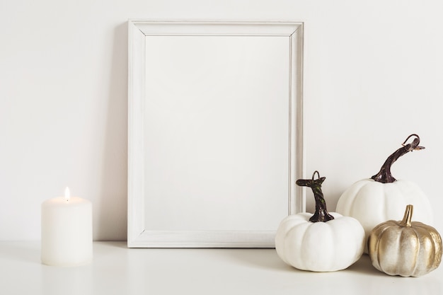 Cadre photo et citrouilles blanches. Espace de copie de maquette pour les illustrations. Décor d'automne à l'intérieur.