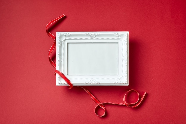 Cadre photo et coeurs et décorations Saint Valentin sur fond rouge. Vue de dessus avec espace de copie. Concept de la Saint-Valentin.