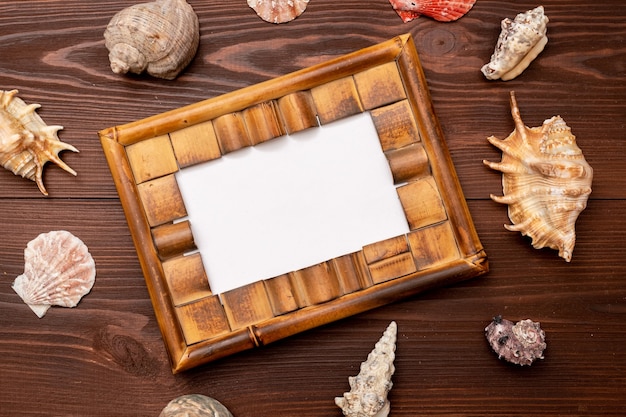 Cadre photo avec coquillages sur surface en bois