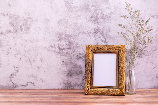 Cadre photo avec fleurs sur mur et table en bois