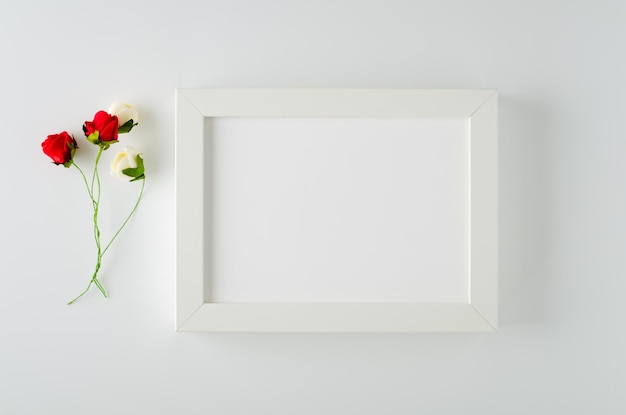 Cadre photo avec roses rouges et blanches sur fond blanc