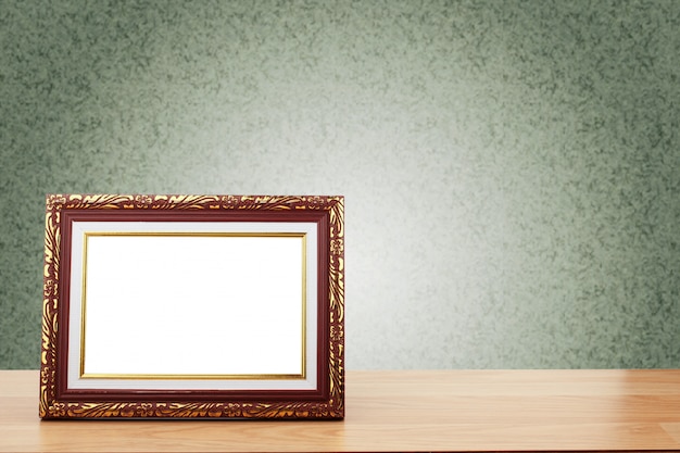 Cadre photo sur une table en bois sur fond de mur végétalisé