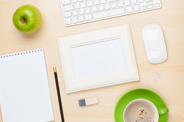 Cadre photo sur table de bureau avec bloc-notes et tasse à café