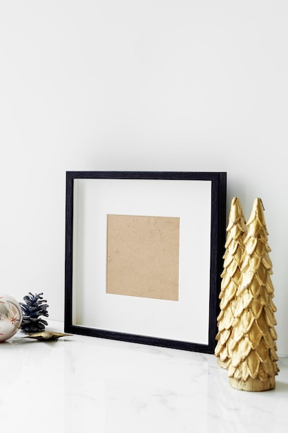 Cadre photo sur une table avec un sapin de Noël doré