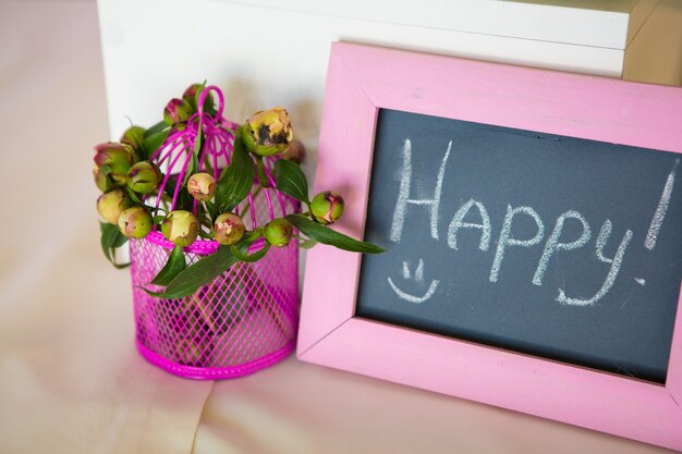 Cadre photo vierge et bouquet de fleurs. Sur table en bois