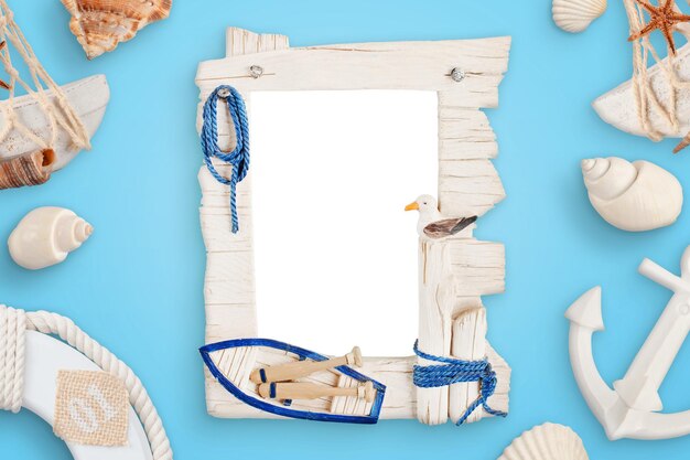 Cadre photo de voyage en mer d'été sur un bureau bleu entouré de coquillages bouée de sauvetage d'ancre de bateau