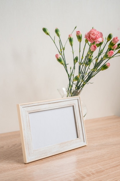 Cadre portrait. Vase en verre moderne avec oeillet rose