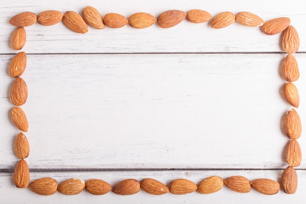 Cadre rectangulaire à base d&#39;amandes sur un fond en bois blanc