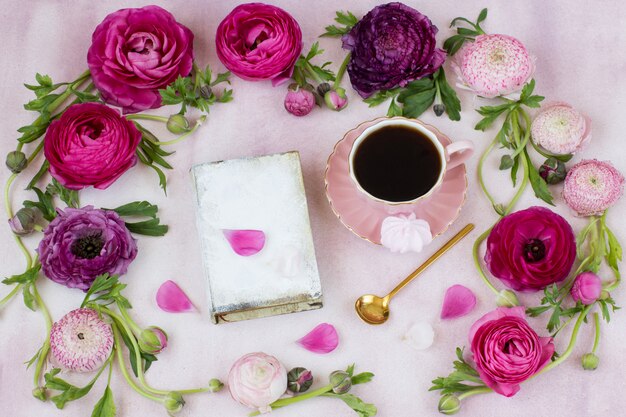 un cadre de renoncule et un livre, une tasse de café